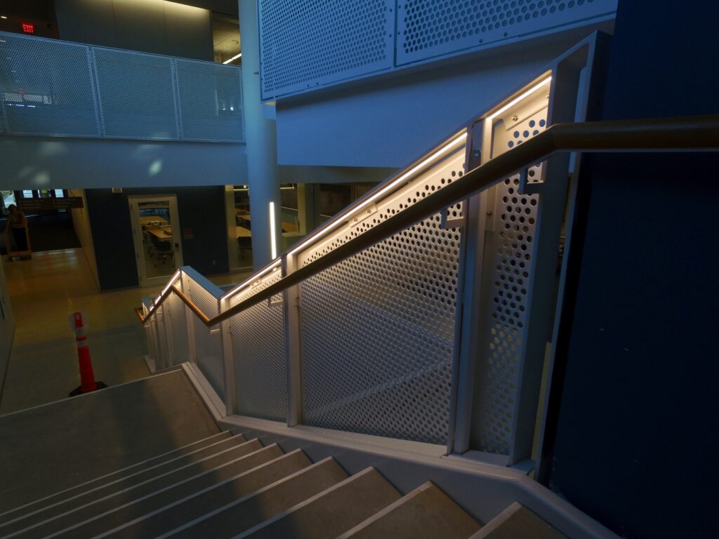 Apollo perforated meta guardrail lit at night